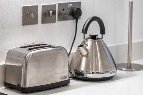 a toaster and a tea kettle on a kitchen counter at Welcoming and Spacious Apartment- Excellent Location in London
