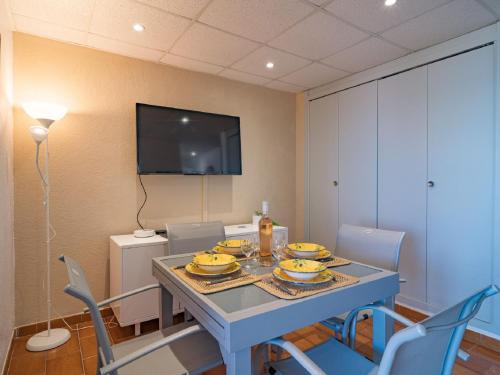 une salle à manger avec une table avec des chaises et une télévision dans l'établissement Apartment Les Jardins de la Plage-12 by Interhome, à Canet