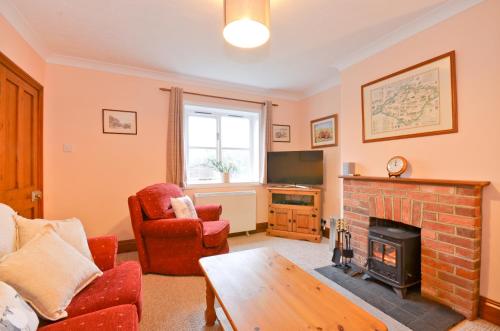 a living room with a fireplace and a tv at The Bays in Bowcombe