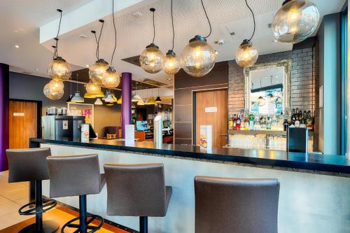a bar in a restaurant with chairs and lights at Premier Inn Frankfurt City Europaviertel in Frankfurt/Main