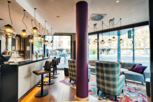 a restaurant with a bar with chairs and tables at Premier Inn Frankfurt City Europaviertel in Frankfurt/Main