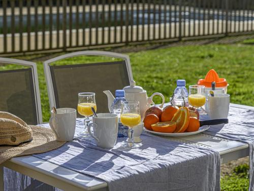 uma mesa com um prato de laranjas e copos de sumo de laranja em Apartment Le Château de Kergonano-21 by Interhome em Baden