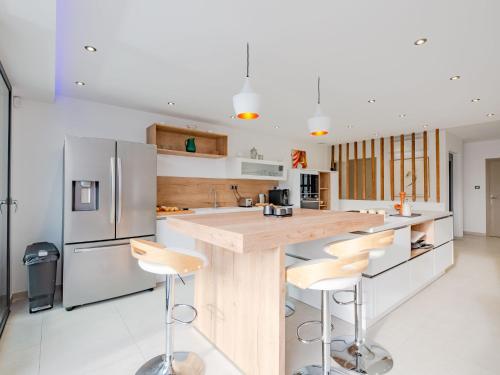une cuisine avec un grand îlot et des tabourets de bar dans l'établissement Villa Les Girelles by Interhome, aux Issambres