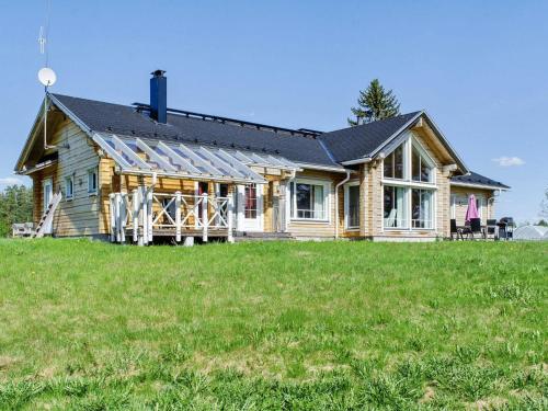 a house with solar panels on top of a field at Holiday Home Wooden ecovilla by Interhome in Haapalahti