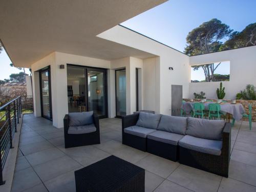 un patio avec un canapé, une table et des chaises dans l'établissement Villa Villa L'Effet Mer by Interhome, à Hyères