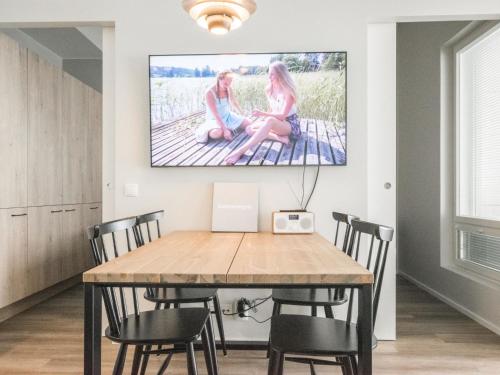una mesa de comedor con sillas y una pintura en la pared en Holiday Home Dagmarin kulma by Interhome, en Ylivieska