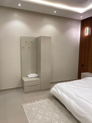 - une chambre avec un lit blanc et un miroir dans l'établissement شقة, à Riyad