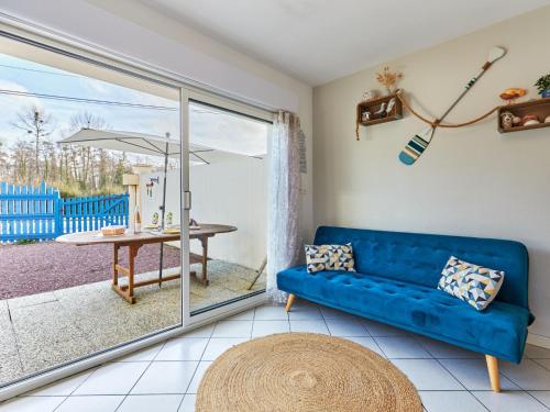 ein Wohnzimmer mit einem blauen Sofa und einem Tisch in der Unterkunft Holiday Home by Interhome 