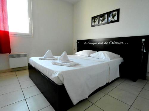 une chambre avec un grand lit blanc avec des serviettes dessus dans l'établissement Apartment Château de Jouarres-3 by Interhome, à Azille