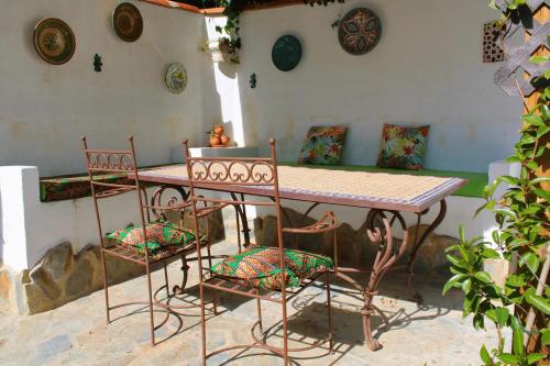 een tafel en twee stoelen en een tafel en enkele borden bij El Balcón de Linares by SIERRA VIVA in Linares de la Sierra