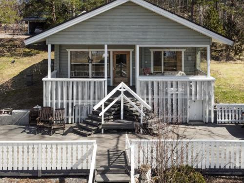 a small gray house with a porch and chairs at Holiday Home Ketunkolo by Interhome in Tampere