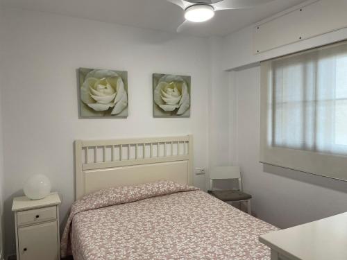 um quarto com uma cama e três flores na parede em Apartamento premium un dormitorio ALCAUDON em Isla Canela