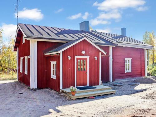 a red shed with a porch and a door at Holiday Home Laattajan hirsipirtti by Interhome in Hyrynsalmi