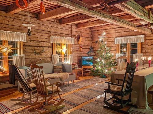 ein Wohnzimmer mit einem Weihnachtsbaum in einer Blockhütte in der Unterkunft Holiday Home Laattajan hirsipirtti by Interhome in Hyrynsalmi