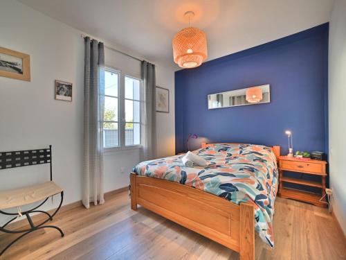 1 dormitorio con cama y pared azul en Holiday Home L'Antioche by Interhome, en Le Château-dʼOléron