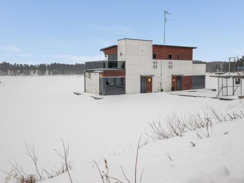 un edificio sentado en la parte superior de un campo cubierto de nieve en Holiday Home Villa rauha by Interhome, en Imatra