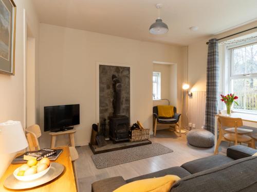 a living room with a couch and a fireplace at Holiday Home Railway House by Interhome in Aviemore