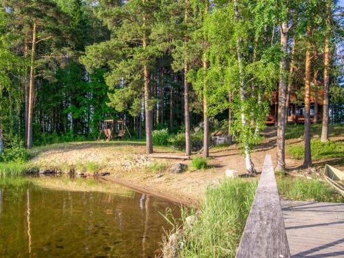 un puente de madera sobre un estanque en un parque en Holiday Home Utras by Interhome, en Punkaharju