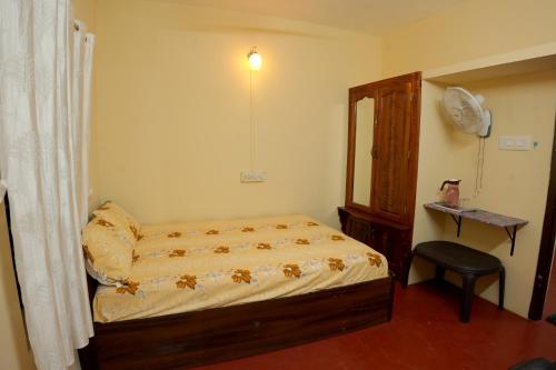 a small bedroom with a bed and a chair at JeeHaa Homestay in Alleppey