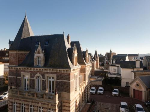 un vieux bâtiment dans une ville avec des voitures garées dans l'établissement Apartment Marbella by Interhome, à Deauville