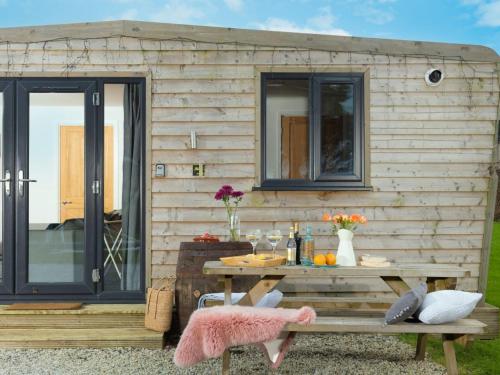 a wooden trailer with a picnic table at Chalet Wheal Amelia Lodge by Interhome in Helston