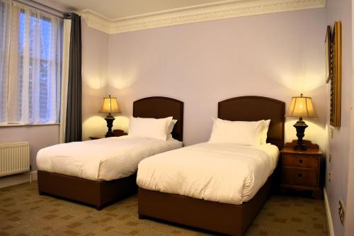 two beds in a room with two lamps at Botleigh Grange Hotel & Spa in Southampton
