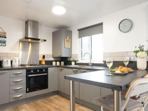 a kitchen with a table with a plate of food on it at Chalet Wheal Jewel Hot Tub Lodge by Interhome in Helston