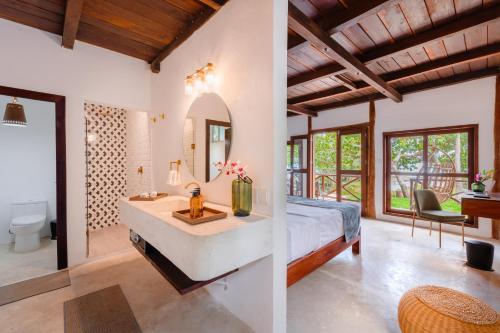 a bedroom with a tub and a sink and a mirror at Hotel Azulea Bacalar - Lagoon Front in Bacalar