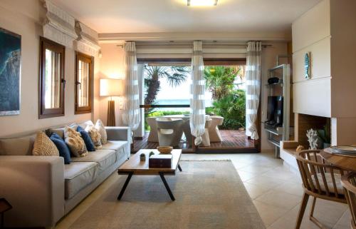 a living room with a couch and a table at Exceptional Beachfront Villa Blue Cocoon in Pefkohori