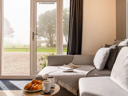 a living room with a couch and a window at Chalet Wheal Rose by Interhome in Helston