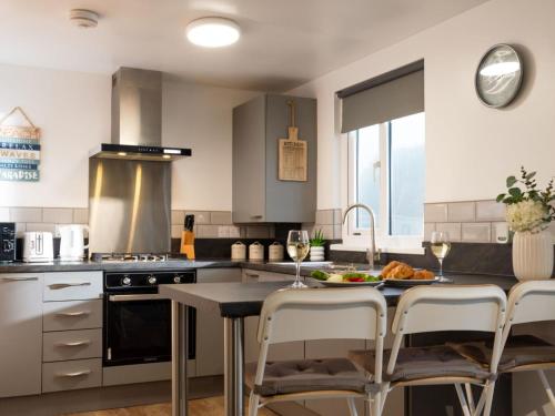 a kitchen with a table with glasses of wine at Chalet Wheal Rose by Interhome in Helston