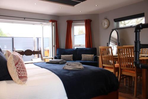 1 dormitorio con 1 cama, 1 silla y 1 sofá en Rare Wood-Fired Hot Tub 2 Bed Get Away In Norfolk, en Norwich