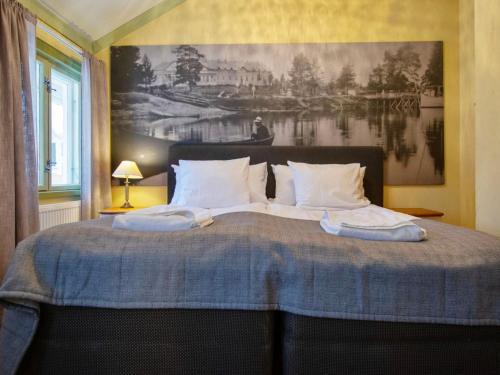 a bedroom with a bed with a painting on the wall at Holiday Home Kartanohuoneisto pekka by Interhome in Runni