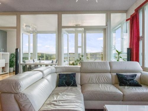 een witte bank in een woonkamer met ramen bij Holiday Home Horisontti penthouse by Interhome in Jyväskylä