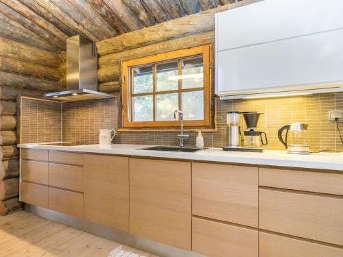 a kitchen with a sink and a window at Holiday Home Kaasavuoren ranta by Interhome in Röölä
