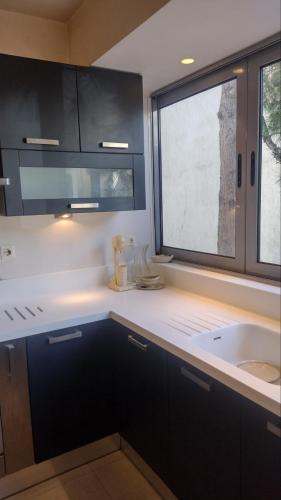 a kitchen with a sink and a window at ΒΙΛΑ ΜΕ ΠΙΣΙΝΑ ΣΤΗΝ ΠΑΙΑΝΙΑ in Paianía