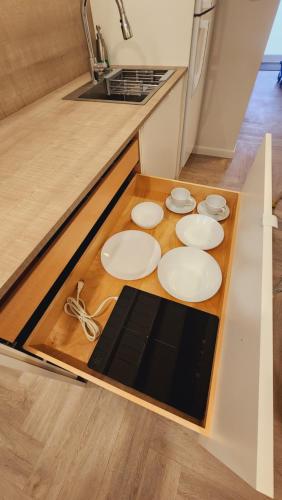 una cocina con placas blancas en una mesa de madera en Private Home Studio Central Located in Miami 2, en Opa-locka