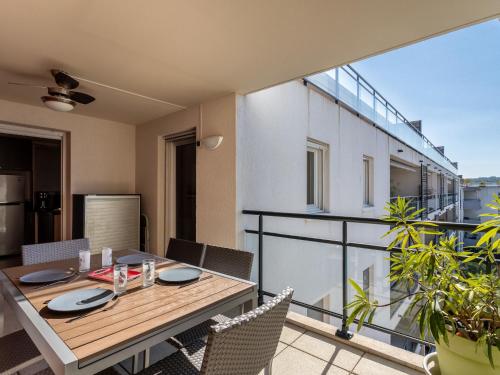Cet appartement dispose d'une terrasse avec une table et des chaises sur un balcon. dans l'établissement Apartment L'Eden-5 by Interhome, au Lavandou