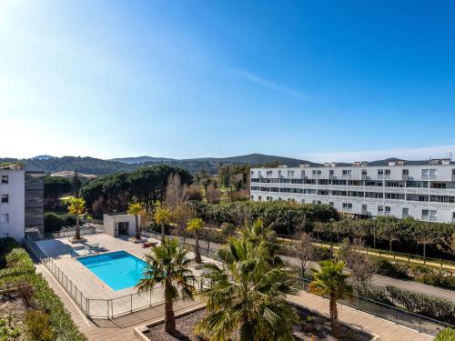 Cet appartement dispose d'une piscine et de palmiers. dans l'établissement Apartment L'Eden-5 by Interhome, au Lavandou