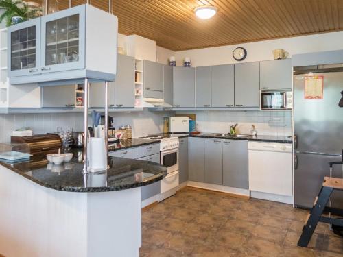 eine große Küche mit weißen Schränken und einer Arbeitsplatte in der Unterkunft Holiday Home Karhuportti by Interhome in Vuokatti