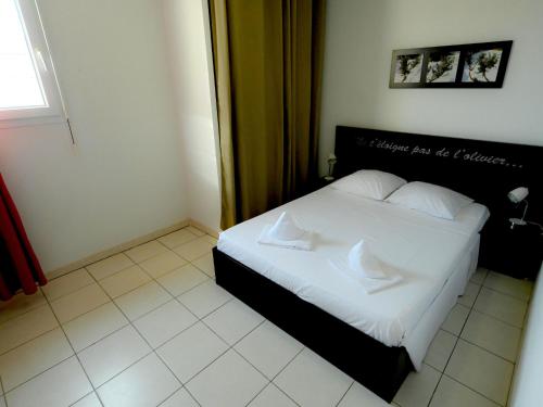 une chambre avec un lit avec des draps blancs et des oreillers dans l'établissement Apartment Château de Jouarres-2 by Interhome, à Azille