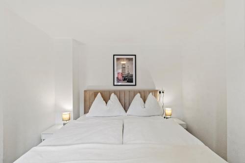 a bedroom with a white bed with two lamps at StayEasy Apartments Leoben P88 #12 in Donawitz