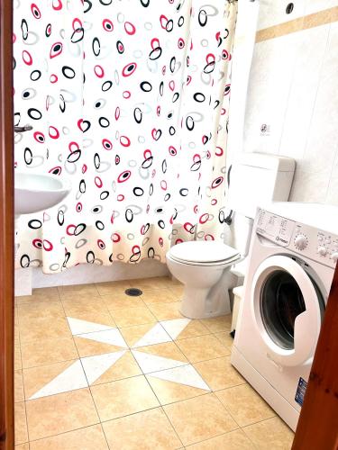 a bathroom with a washing machine and a shower curtain at Orfanos Houses No2 in Koroni