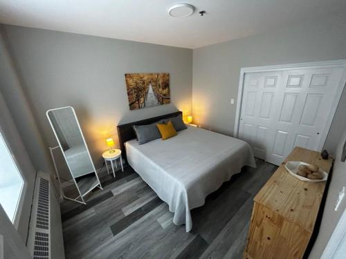 a bedroom with a large white bed and a table at NEW Large Luxurious 2BR Condo in the Heart of Uptown Coffee, Wifi in Saint John