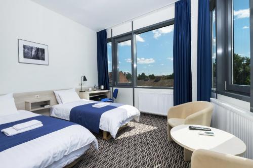 a hotel room with two beds and a window at Kaunas City in Kaunas