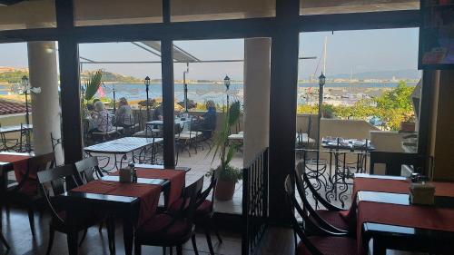 un ristorante con tavoli e sedie e vista sull'acqua di Stankoff Hotel a Nesebar