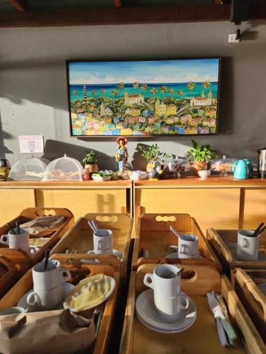 uma sala de jantar com mesas de madeira e uma televisão em Kaapalua em Porto de Galinhas