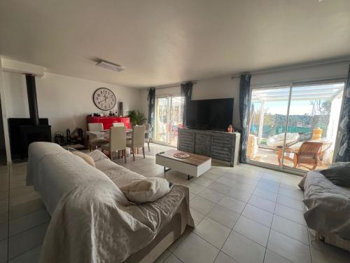 un salon avec un canapé et une télévision dans l'établissement Maison de charme avec piscine privée à Grasse, à Grasse