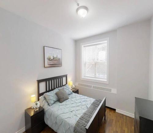 a bedroom with a bed with two night stands and a window at Bright Cozy Condo The Heart of Uptown 2BED Coffee & tea in Saint John