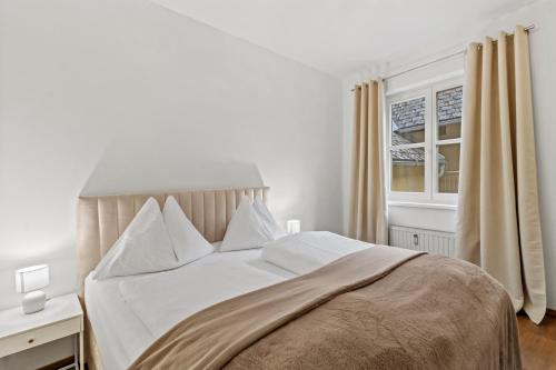 a bedroom with a bed with white sheets and a window at StayEasy Apartments Mautern #11 in Mautern in Steiermark